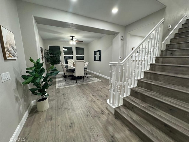 interior space featuring ceiling fan, stairs, baseboards, and wood finished floors