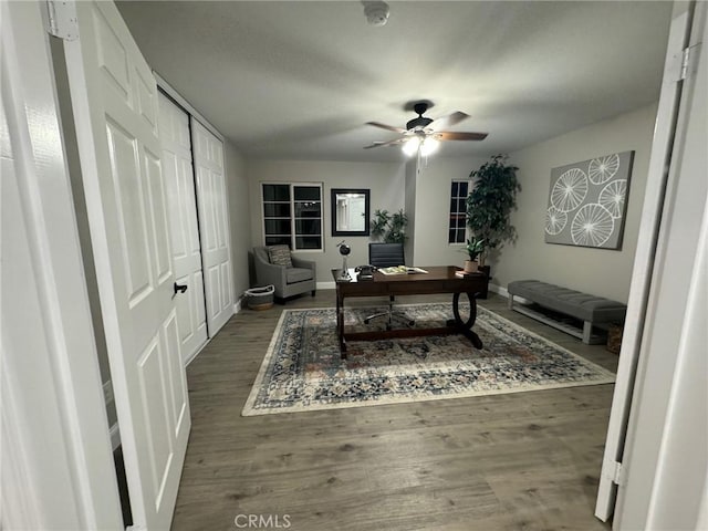 office with wood finished floors, a ceiling fan, and baseboards