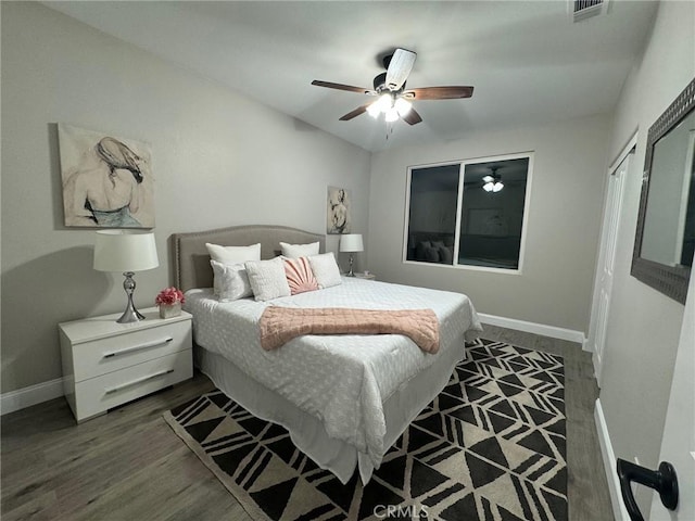 bedroom featuring ceiling fan, wood finished floors, visible vents, and baseboards