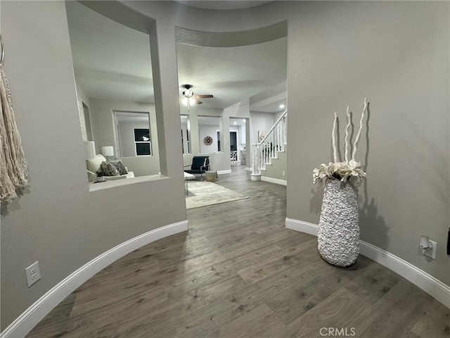 foyer entrance featuring stairs, ceiling fan, wood finished floors, and baseboards