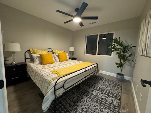 bedroom featuring baseboards, visible vents, ceiling fan, and wood finished floors