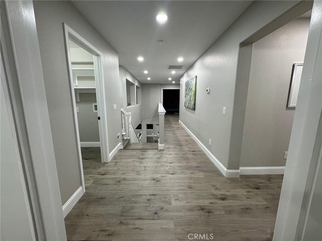 hall with recessed lighting, visible vents, baseboards, and wood finished floors