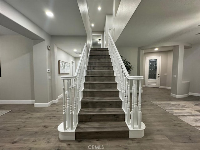 stairs with recessed lighting, wood finished floors, and baseboards