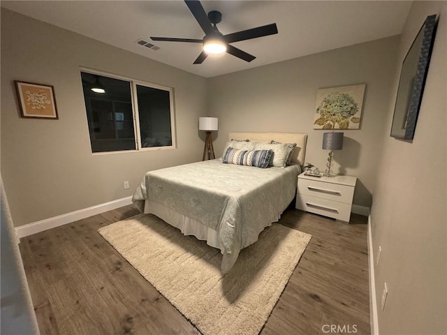 bedroom featuring baseboards, visible vents, ceiling fan, and dark wood-style flooring