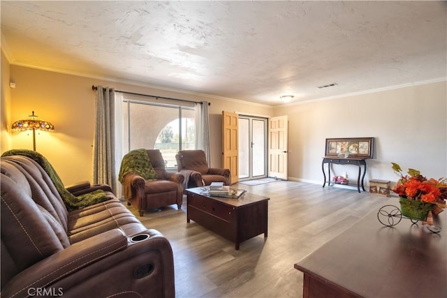 living area with ornamental molding and wood finished floors