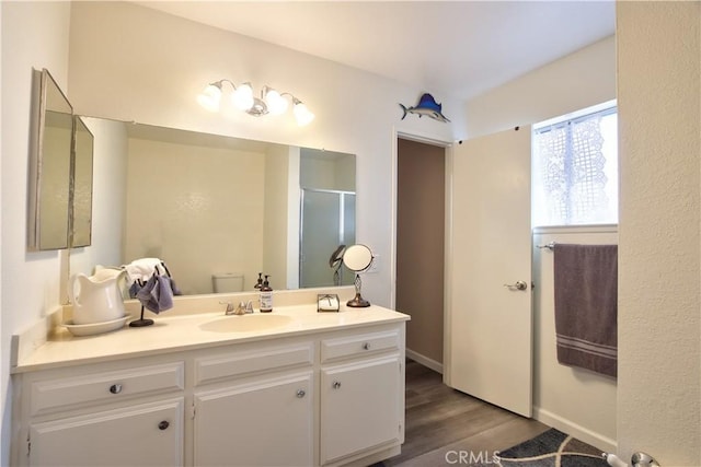 full bath with toilet, a shower stall, wood finished floors, and vanity