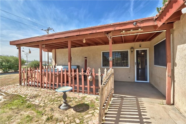 doorway to property with a patio area and stucco siding