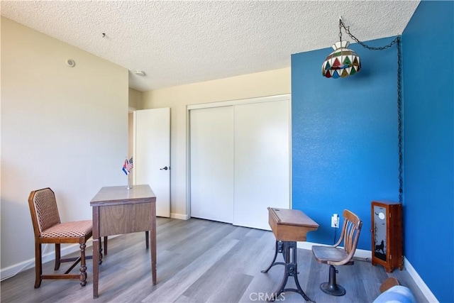 office with a textured ceiling, baseboards, and wood finished floors