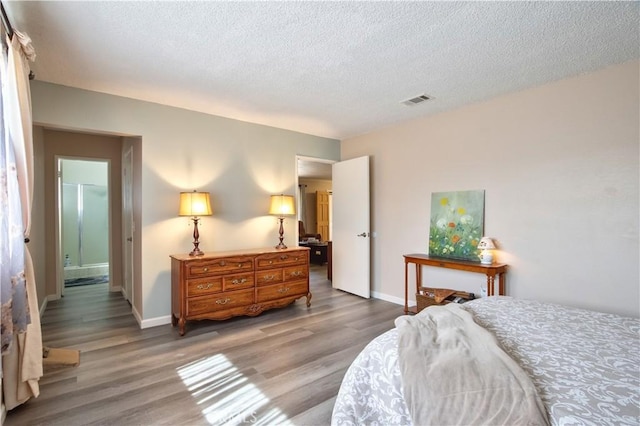 bedroom featuring wood finished floors, visible vents, and baseboards