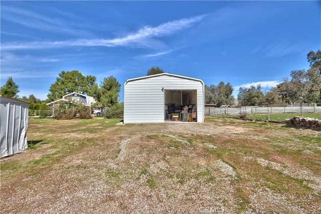 view of outbuilding with fence and an outbuilding