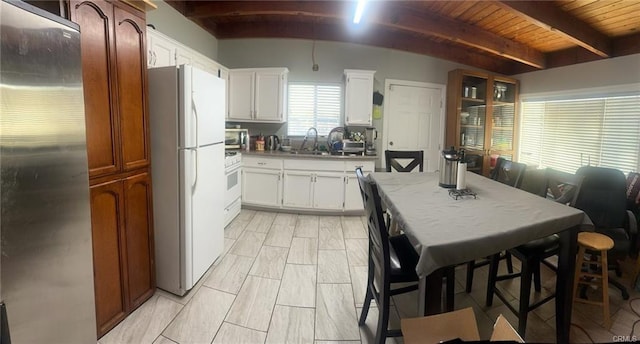 kitchen featuring wooden ceiling, stainless steel appliances, a sink, white cabinetry, and beam ceiling