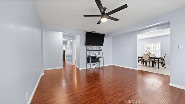 living room featuring ceiling fan, baseboards, and wood finished floors