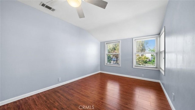 empty room featuring baseboards, visible vents, a ceiling fan, lofted ceiling, and wood finished floors