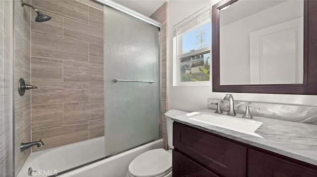 bathroom with toilet, combined bath / shower with glass door, and vanity