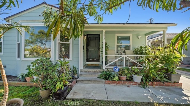 view of exterior entry with covered porch