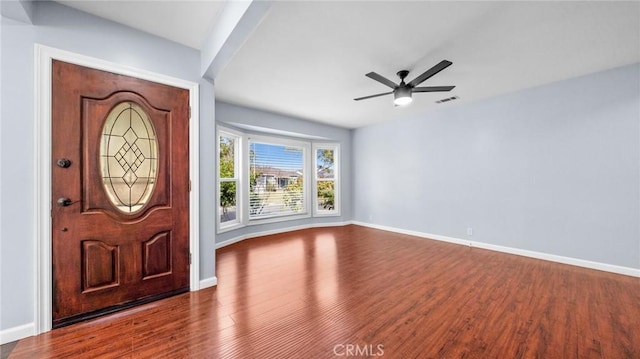 foyer featuring visible vents, ceiling fan, baseboards, and wood finished floors