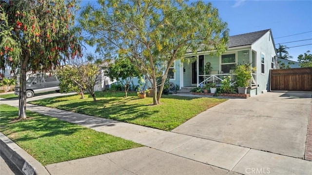 obstructed view of property with a porch, fence, and a front lawn