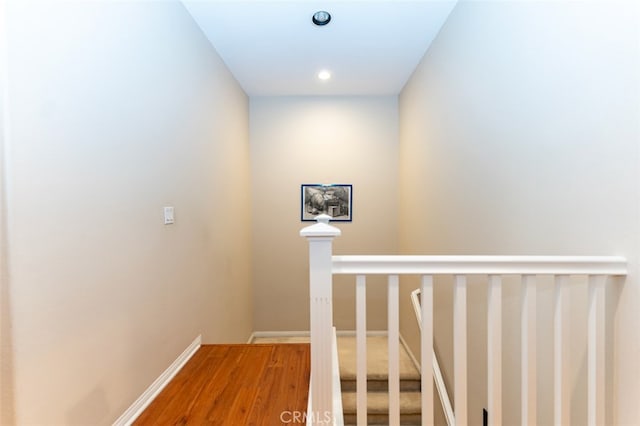 stairway with baseboards and wood finished floors