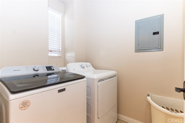 clothes washing area featuring laundry area, electric panel, baseboards, and washing machine and clothes dryer