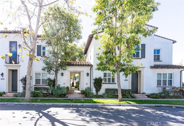 view of front of property with a tiled roof and stucco siding