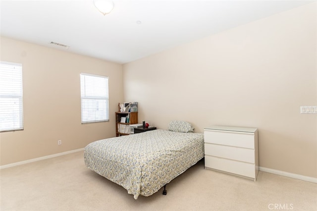 bedroom featuring light carpet, visible vents, and baseboards