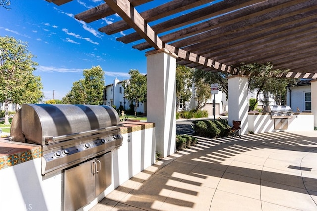 view of patio featuring exterior kitchen and a pergola