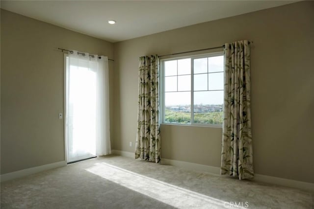 carpeted empty room featuring baseboards