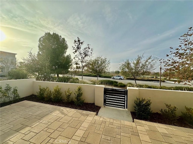 view of patio / terrace featuring a fenced front yard and a gate