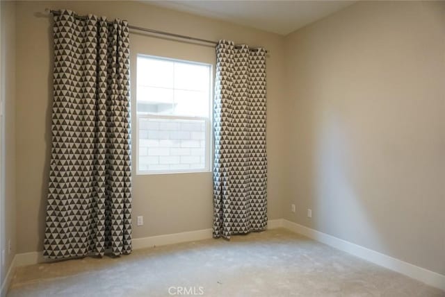 empty room featuring carpet floors and baseboards