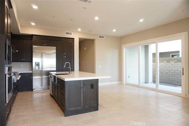 kitchen featuring visible vents, stainless steel appliances, light countertops, a sink, and recessed lighting