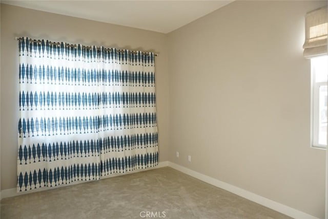 spare room with carpet and baseboards