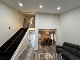 living area with stairs, wood finished floors, and recessed lighting