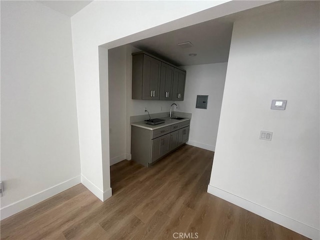 bar with a sink, baseboards, and wood finished floors