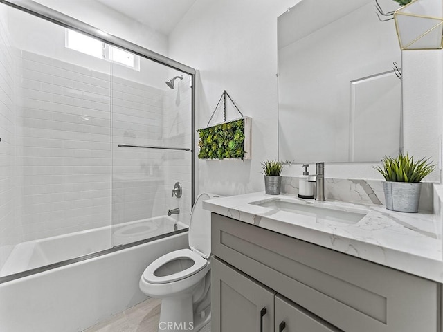 full bath with toilet, shower / bath combination with glass door, and vanity