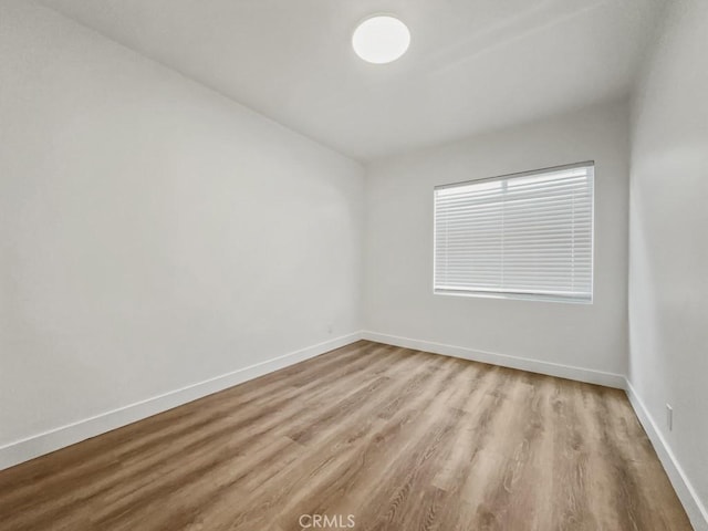 empty room featuring baseboards and wood finished floors