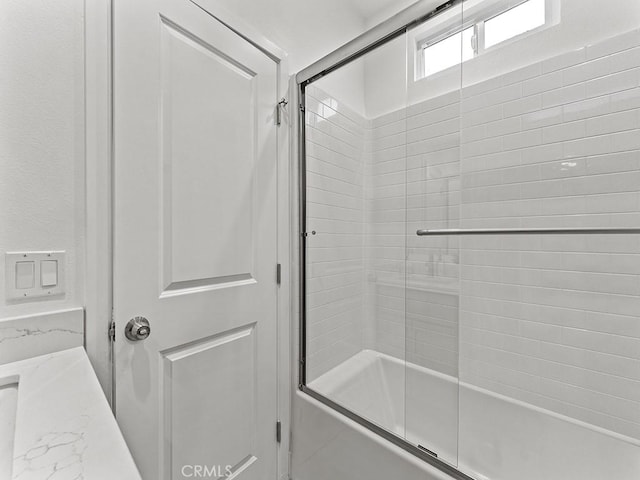 bathroom featuring bath / shower combo with glass door