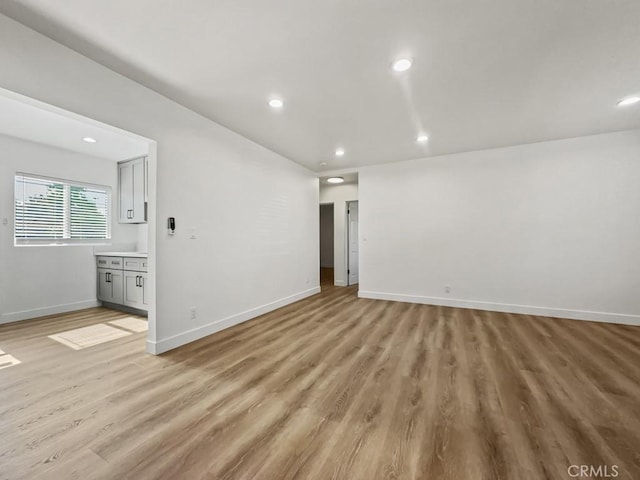 unfurnished room with light wood-style floors, recessed lighting, and baseboards