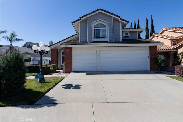 traditional-style home featuring concrete driveway, a tile roof, and an attached garage