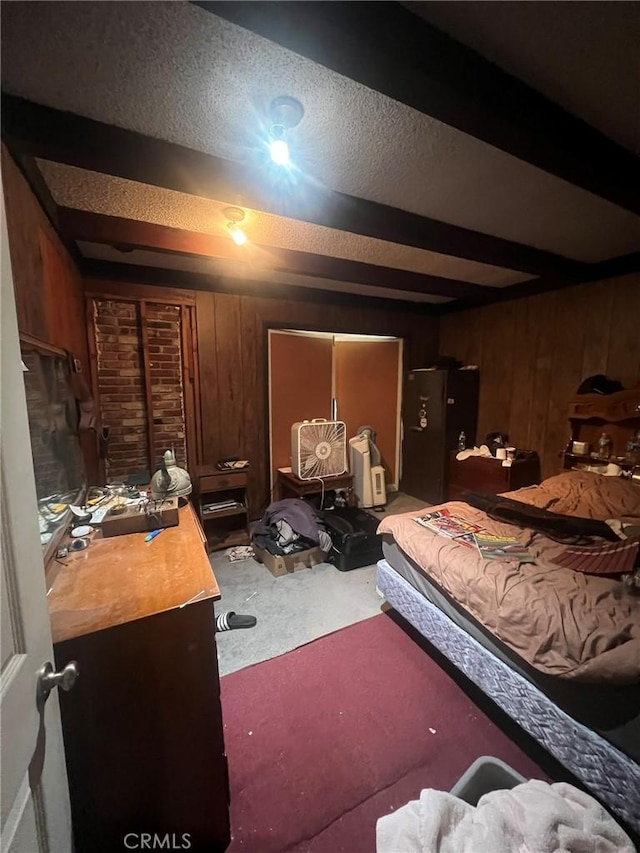 bedroom featuring wood walls, a textured ceiling, and beamed ceiling