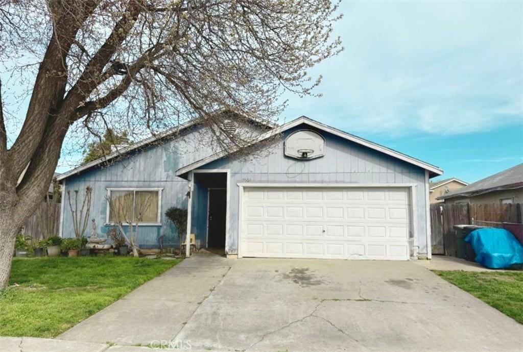 ranch-style house with a garage, concrete driveway, a front yard, and fence