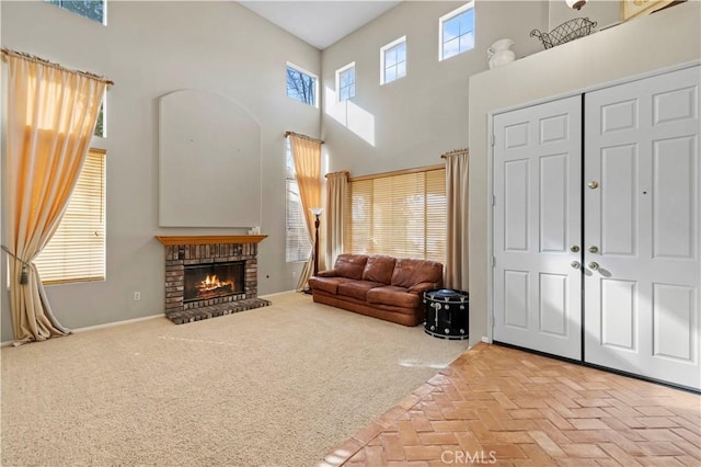 carpeted living room featuring a high ceiling and a fireplace