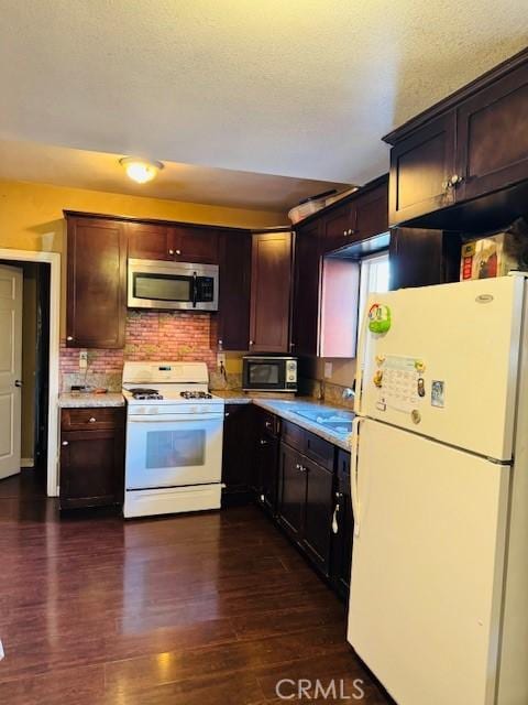 kitchen featuring dark wood finished floors, tasteful backsplash, light countertops, dark brown cabinets, and white appliances