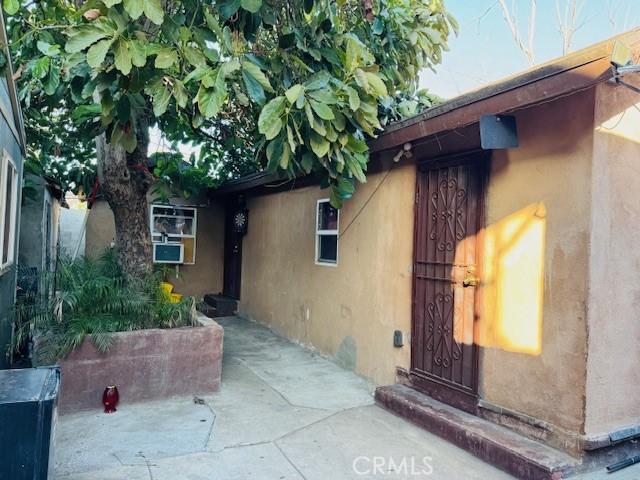 doorway to property featuring stucco siding and a patio