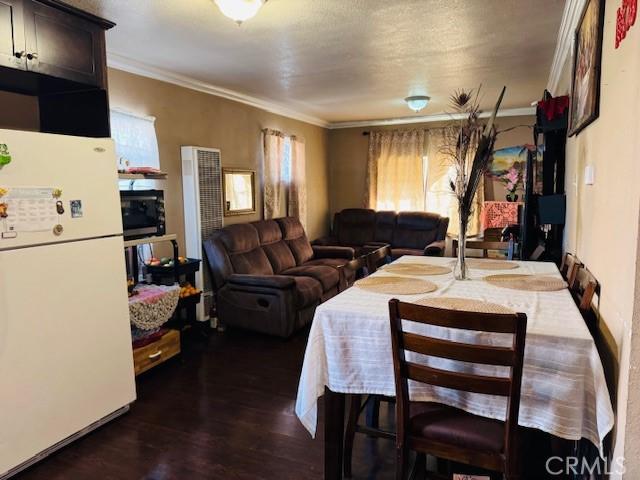 dining room with ornamental molding and dark wood-style flooring