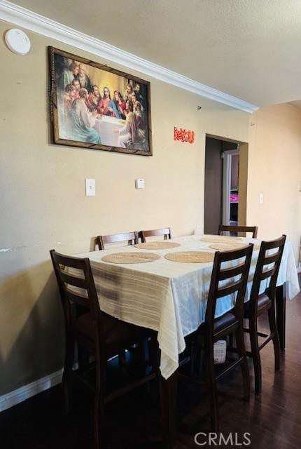 dining space with ornamental molding, wood finished floors, and baseboards