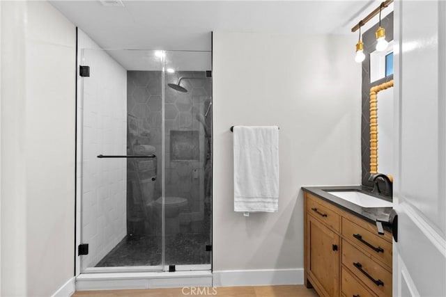 full bathroom featuring baseboards, a shower stall, and vanity