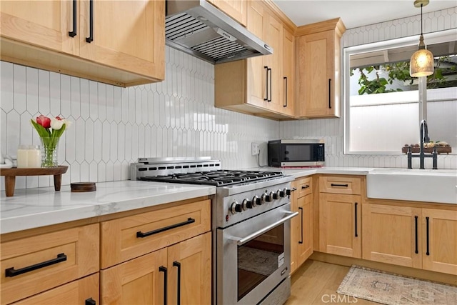 kitchen with decorative backsplash, light brown cabinets, under cabinet range hood, a sink, and stainless steel appliances