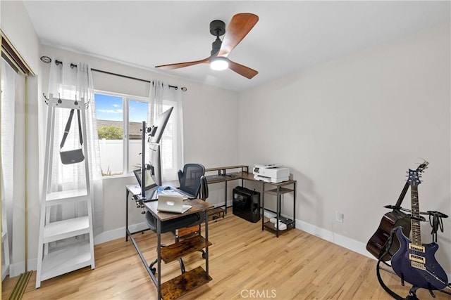 home office featuring baseboards, a ceiling fan, and wood finished floors
