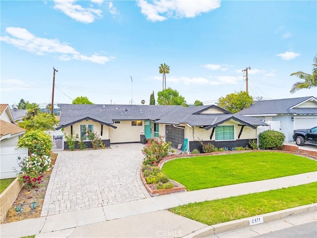 single story home featuring fence, stucco siding, a front lawn, and decorative driveway