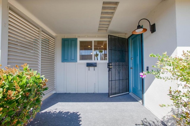 property entrance featuring board and batten siding and stucco siding